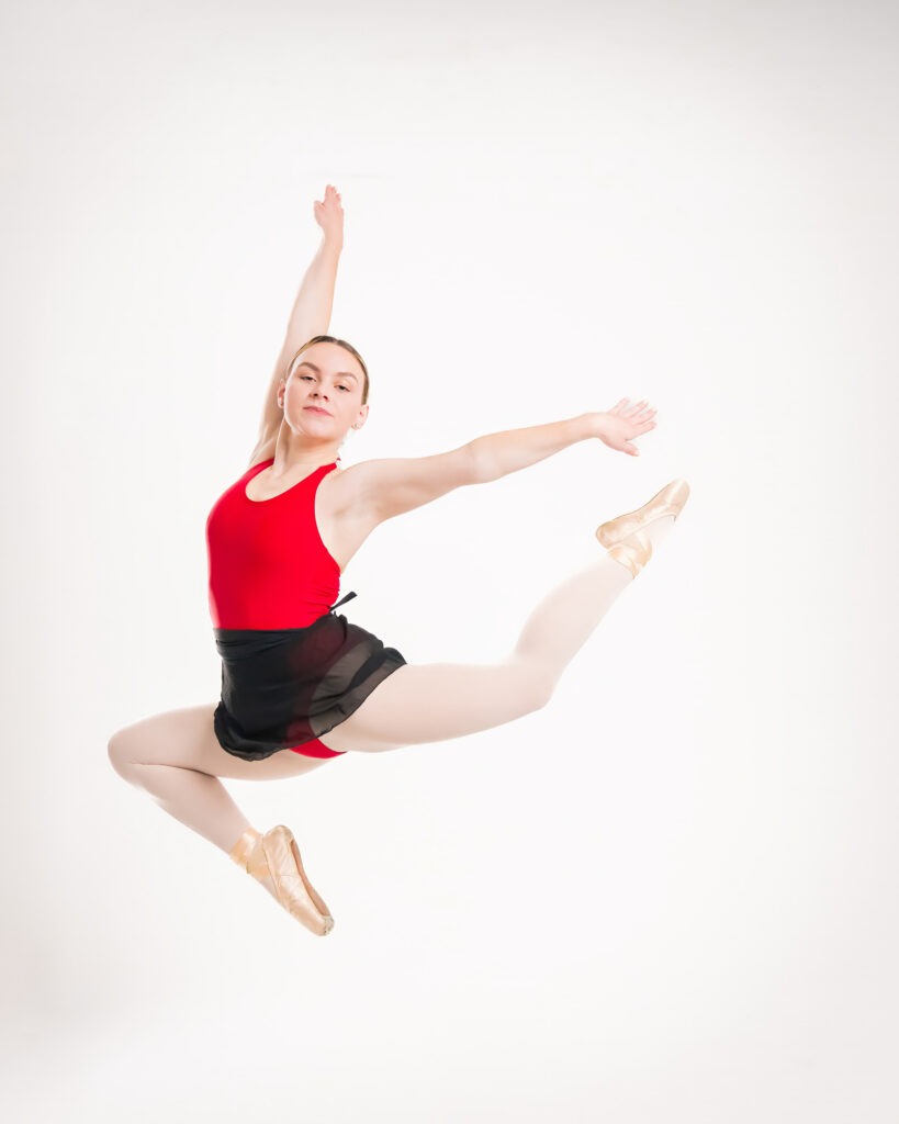Ballerina dancer pointe shoes white studio backdrop jumping