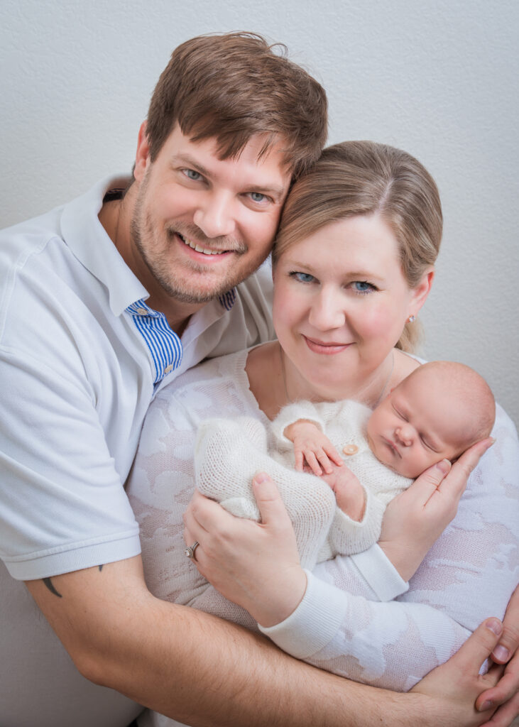 Newborn baby parents white home studio